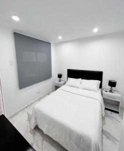 1 dormitorio blanco con 1 cama grande y 2 mesitas de noche en Departamento La Punta B - Piscina - Zona parrilla en Lima