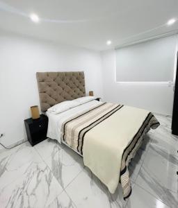 Dormitorio blanco con cama y pared blanca en Departamento La Punta B - Piscina - Zona parrilla en Lima
