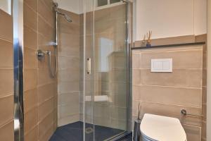 a bathroom with a glass shower with a toilet at sabbia bianca in Alassio +6 photos