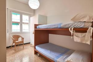 a bedroom with two bunk beds and a chair at sabbia bianca in Alassio