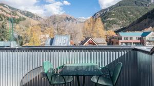 a table and chairs on a balcony with mountains at Hotel Columbia in Telluride