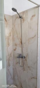 una ducha con una manguera en una pared de mármol en Holiday Home 2 Palma en Durrës