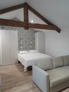 ein Schlafzimmer mit einem Bett und einem Sofa in der Unterkunft Place Barbe in Dijon