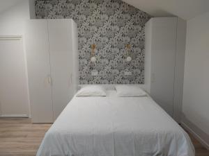 1 dormitorio con cama blanca y pared en Place Barbe en Dijon