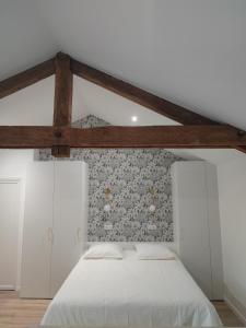 - une chambre avec un lit blanc et un mur dans l'établissement Place Barbe, à Dijon