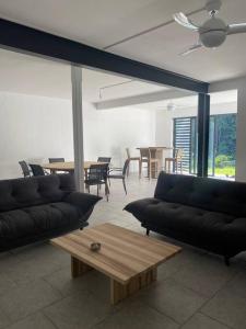 Sala de estar con sofás y mesa de centro en Spacieux appartement à La Villa Montagne, en Le Carbet