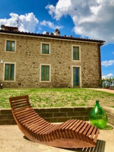 a wooden bench sitting in front of a building at Sangi Chianti Vacations in Poggibonsi