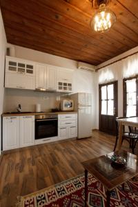 a kitchen with white cabinets and a wooden ceiling at Emblematic House Apartment 1 in Gjirokastër