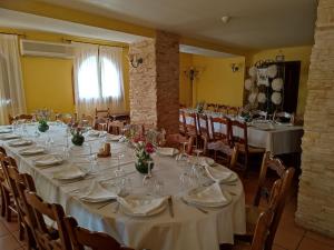 ein langer Tisch mit weißen Tischdecken und Blumen darauf in der Unterkunft El Sester in Torremanzanas