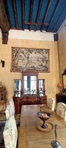 a dining room with a table and a painting on the wall at Chateau de la Grand'Maison in Bellême