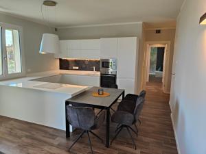 eine Küche mit einem Tisch und Stühlen im Zimmer in der Unterkunft San Giorgio Design Home in Colà di Lazise