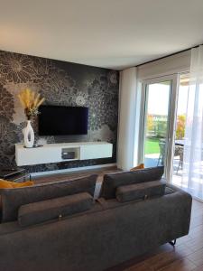ein Wohnzimmer mit einem Sofa und einem Flachbild-TV in der Unterkunft San Giorgio Design Home in Colà di Lazise
