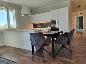 eine Küche mit einem Tisch und 4 Stühlen in der Unterkunft San Giorgio Design Home in Colà di Lazise