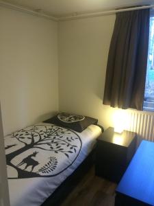 a bedroom with a bed with a tree design on it at Vosseven 27 Heksenkring in Stramproy