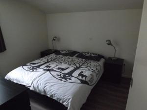 ein Schlafzimmer mit einem schwarzen und weißen Bett mit zwei Lampen in der Unterkunft Vosseven 27 Heksenkring in Stramproy