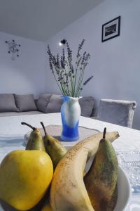 a table with a bowl of pears and a vase at Apartment Z in Zlarin