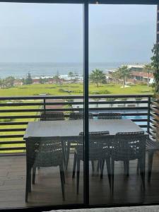 a table and chairs with a view of the ocean at Nice appartement pool & sea view in Dar Bouazza