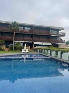 une grande piscine en face d'un bâtiment dans l'établissement Nice appartement pool & sea view, à Dar Bouazza