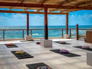 una sala de yoga con el océano en el fondo en Amansala Resort, en Tulum