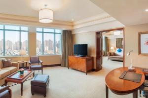 uma sala de estar com um sofá e uma televisão em The Hongta Hotel, A Luxury Collection Hotel, Shanghai em Xangai