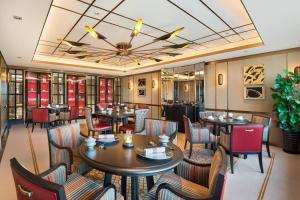 un restaurant avec des tables et des chaises et un plafond dans l'établissement The Hongta Hotel, A Luxury Collection Hotel, Shanghai, à Shanghai