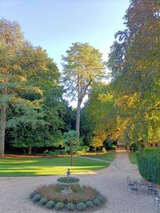 a fountain in the middle of a park with trees at Chateau de la Grand'Maison in Bellême