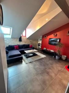 uma sala de estar com um sofá azul e uma televisão em Appart en duplex climatisé cœur de ville em Périgueux