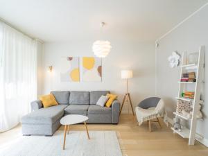 a living room with a gray couch and a chair at Rosendahl - 75m2 Charming Two-story Apt next to the Best Beach and Scenic Park - Free Parking, Easy Check-in, Near Downtown in Tampere
