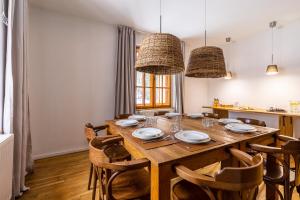 a dining room with a wooden table and chairs at Biały Dom W ROPKI in Ropki