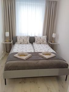 ein Schlafzimmer mit einem Bett mit zwei Handtüchern darauf in der Unterkunft Moon Apartment in Breslau