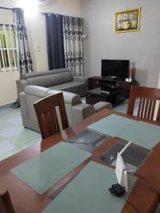 sala de estar con mesa y sofá en Superbe Appartement COTONOU Place de L'étoile rouge, en Cotonou