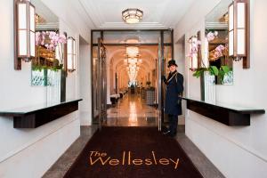 Una donna in piedi nel corridoio di un edificio di The Wellesley, a Luxury Collection Hotel, Knightsbridge, London a Londra