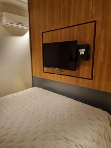 a bedroom with a bed and a tv on a wall at Apart Rivadavia340 in Neuquén +11 photos