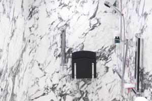 uma parede de mármore branco com uma cadeira preta na casa de banho em The Wellesley, a Luxury Collection Hotel, Knightsbridge, London em Londres