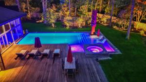 an overhead view of a swimming pool with tables and chairs at Enjoy the Spa all year round in this EHV Estate in East Hampton