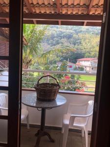 una mesa con una cesta delante de una ventana en Pousada Bizkaia, en Florianópolis