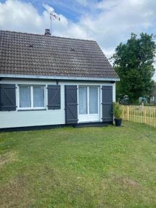 une maison blanche avec une clôture et une cour dans l'établissement Les Lucioles Fort-Mahon Plage, à Fort-Mahon-Plage