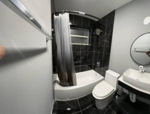 een badkamer met een toilet, een wastafel en een spiegel bij Happeace in Pompano Beach