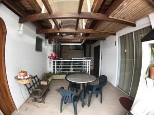 un patio con mesa, sillas y techo en Pousada Bizkaia, en Florianópolis