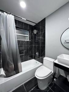 een zwart-witte badkamer met een toilet en een wastafel bij Happeace in Pompano Beach