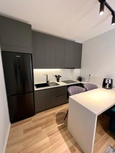 a kitchen with a black refrigerator and a table at Center of Tirana - Apartment in Tirana