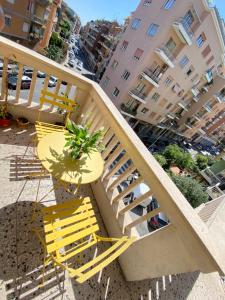 une chaise jaune et une plante assise sur un balcon dans l'établissement a due passi da San Pietro, à Rome