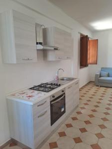 una cucina bianca con piano cottura e lavandino di Villa Paola a Capaci