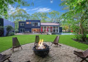 a fire pit in the backyard of a house at Enjoy the Spa all year round in this EHV Estate in East Hampton