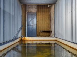 a room with a door and a pool of water at Rainbow Motel & Hot Pools in Turangi