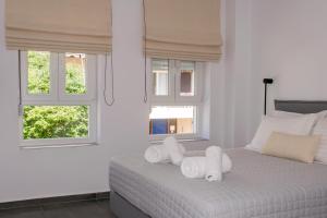 a white bedroom with white towels on a bed at Gioia I & Gioia II in Rethymno Town