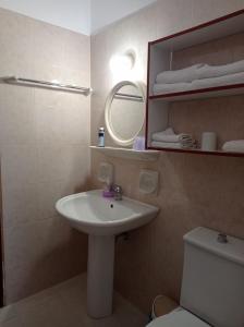 a bathroom with a sink and a toilet and a mirror at Studios Ioanna Limnionas Samos in Ayía Kiriakí