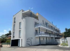 un edificio blanco con escaleras al costado en Superbe appartement neuf entre mer et pins Wifi en Argelès-sur-Mer