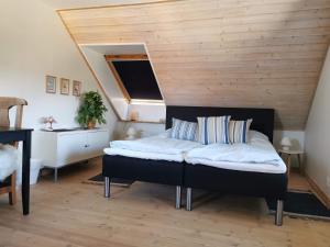 a bedroom with a bed with a wooden ceiling at Safine B&B in Fåborg