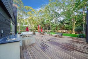a backyard with a kitchen and a wooden deck at Enjoy the Spa all year round in this EHV Estate in East Hampton